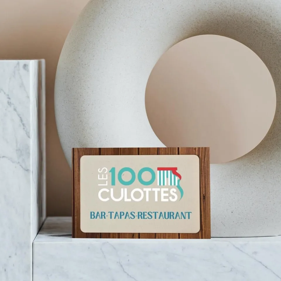 Enseigne Les 100 Culottes, bar tapas restaurant, sur un présentoir en bois