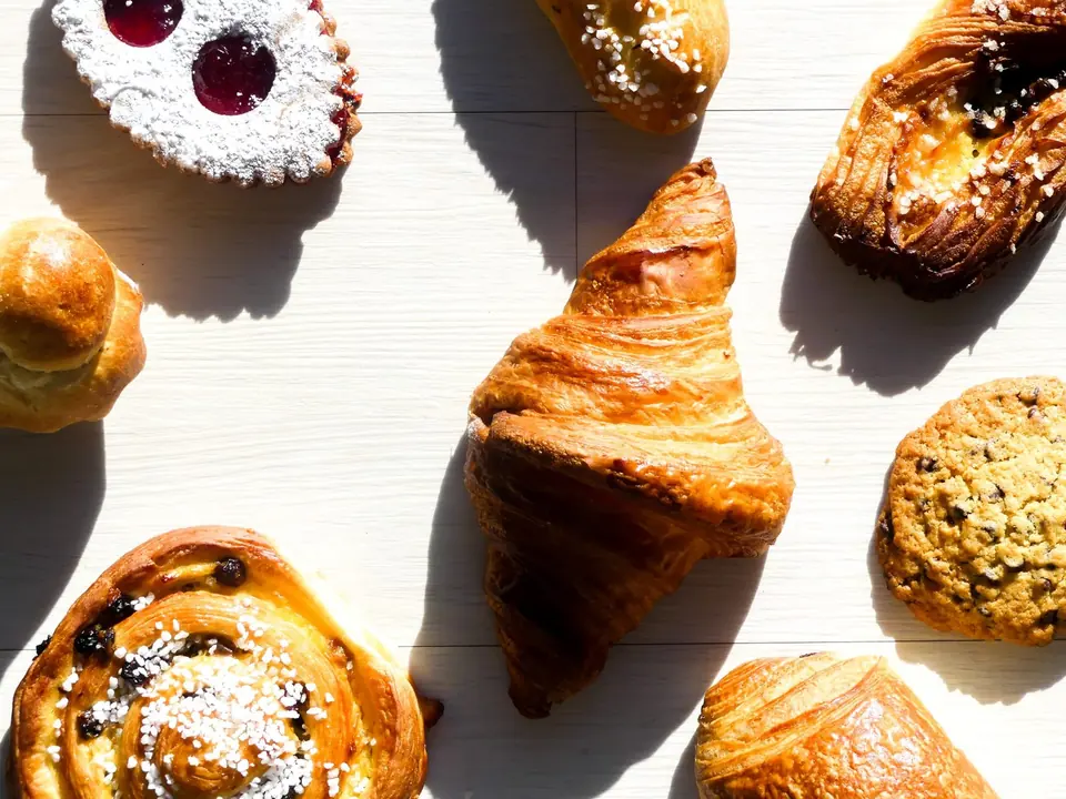 Croissants, pains aux raisins et sablés à la confiture vus de dessus